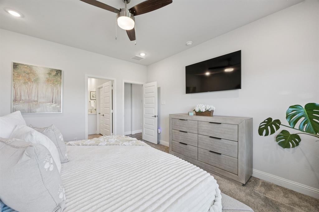 722 Cari Lane Forney, TX 75126 - Photo 16 of 40 a bedroom with a bed and a flat screen tv