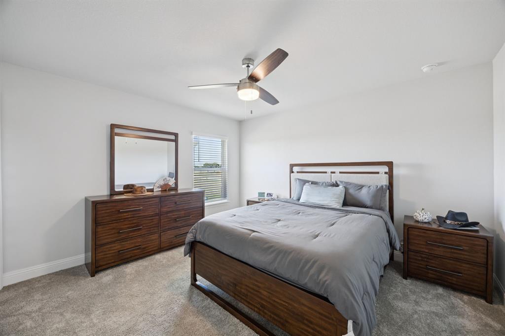 722 Cari Lane Forney, TX 75126 - Photo 21 of 40 a bedroom with a bed and a chandelier