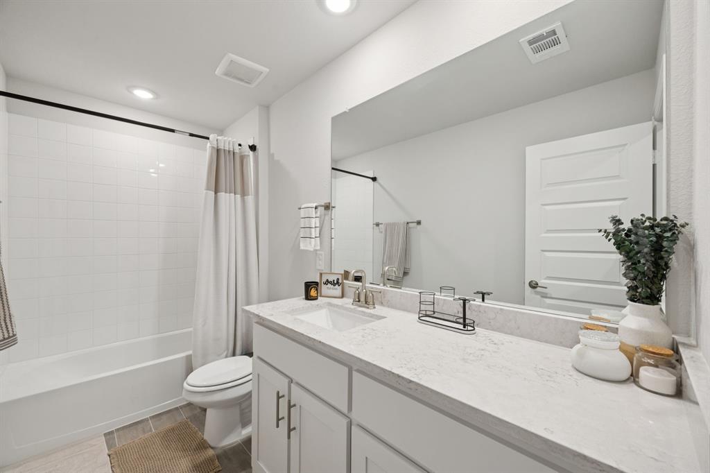 722 Cari Lane Forney, TX 75126 - Photo 23 of 40 a bathroom with a granite countertop sink mirror vanity and toilet