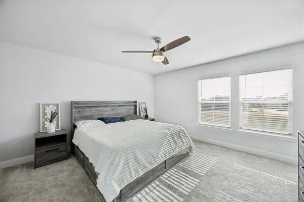a bedroom with a large bed and a ceiling fan