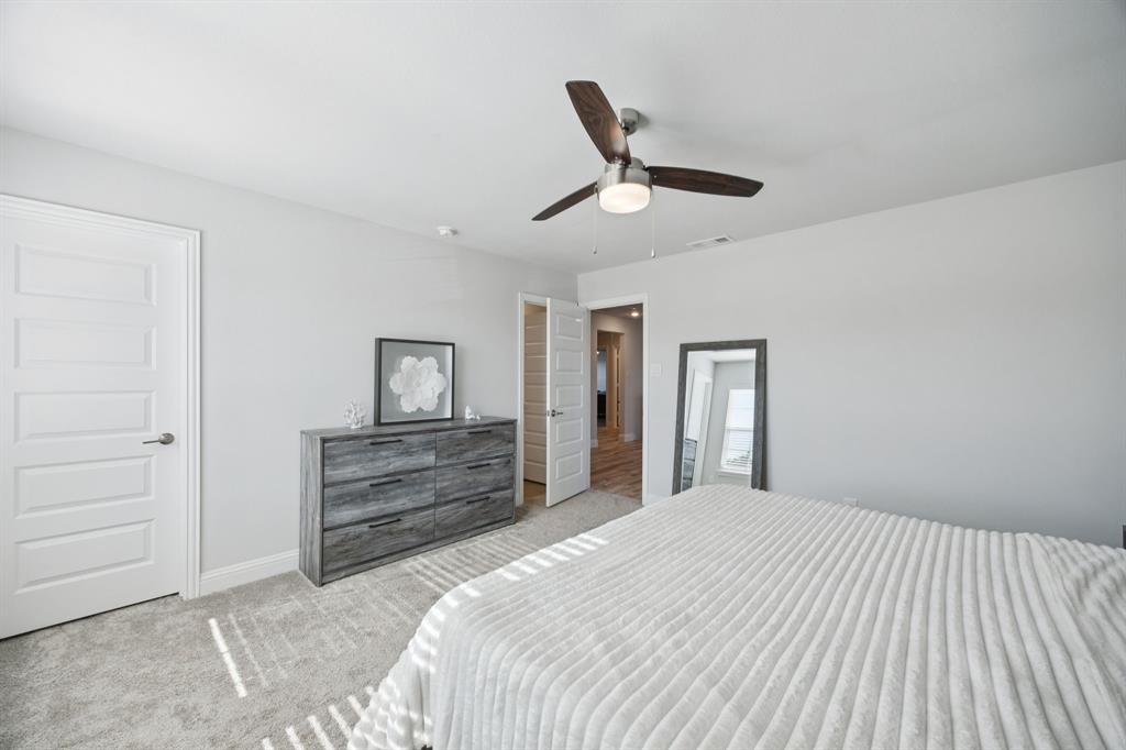 722 Cari Lane Forney, TX 75126 - Photo 25 of 40 a bedroom with a bed and a dresser