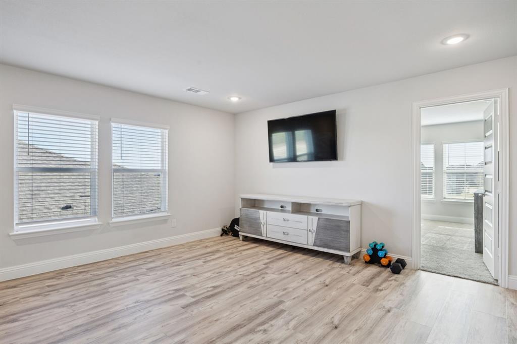 722 Cari Lane Forney, TX 75126 - Photo 30 of 40 an empty room with wooden floor and windows