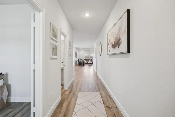 a view of a hallway with wooden floor and furniture