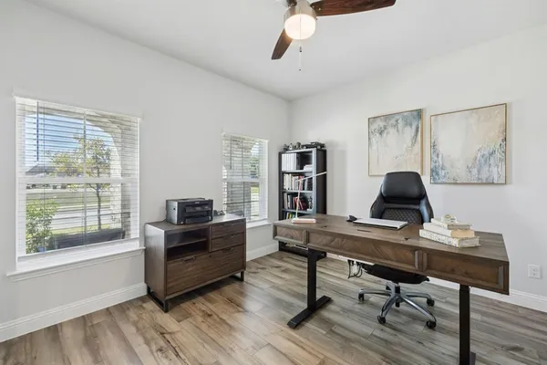 a view of a workspace with furniture and a window