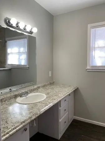 a bathroom with a granite countertop sink and a mirror
