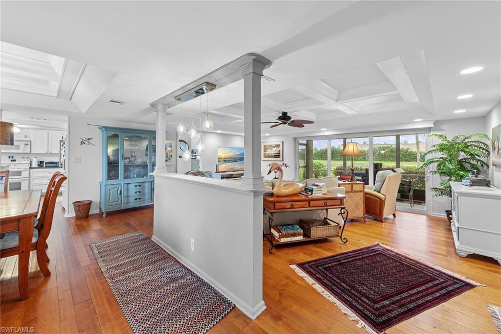 287 Albi Road, Unit 2803 Naples, FL 34112 - Photo 8 of 50 Kitchen with white appliances, coffered ceiling, ceiling fan, light wood-type flooring, and decorative columns