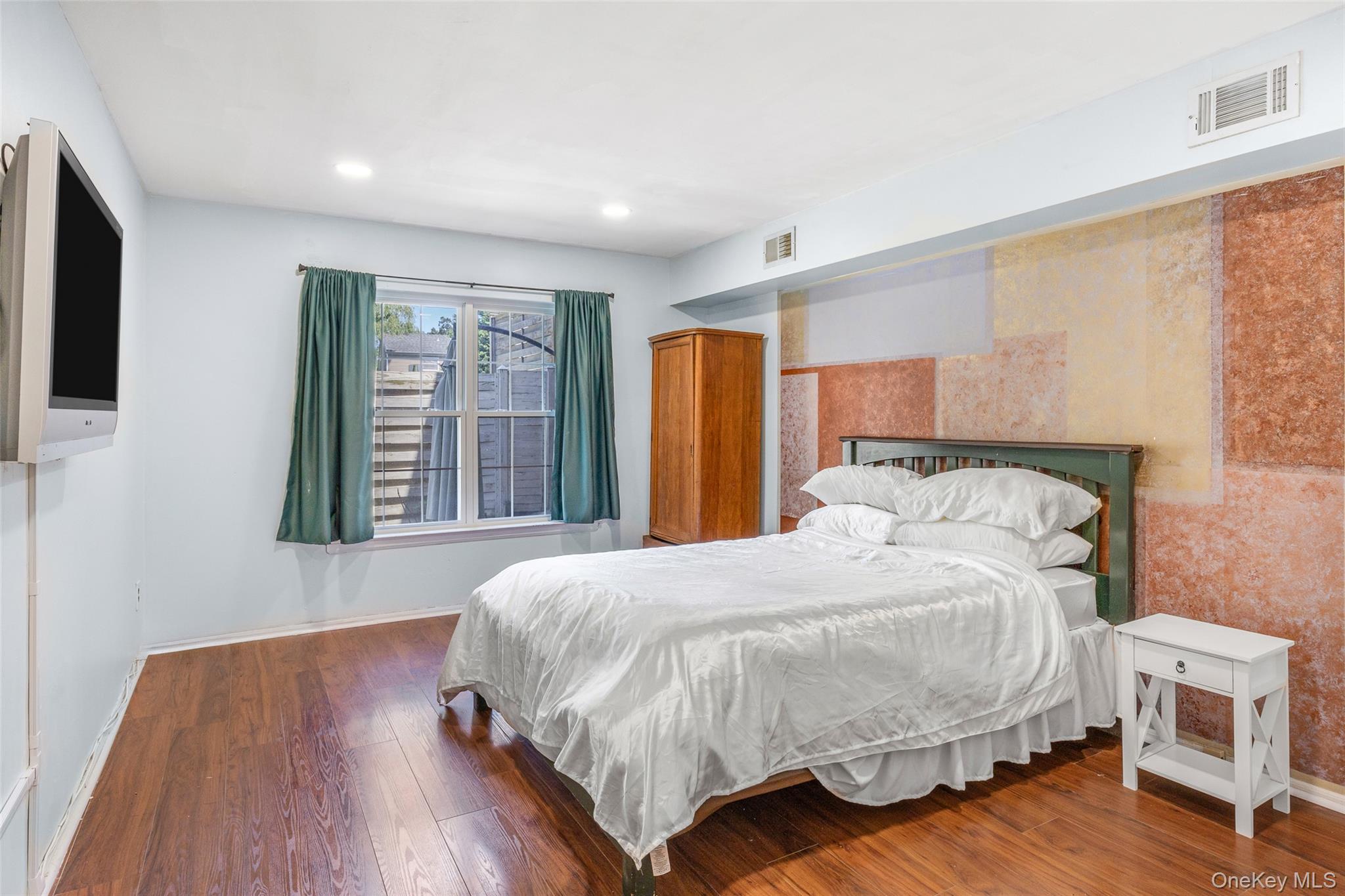 655 Middle Country Road, Unit 1G1 Coram, NY 11727 - Photo 9 of 15 a bedroom with a bed and a flat screen tv