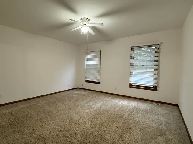 an empty room with windows and closet