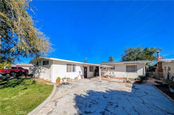 a view of a house with backyard and sitting area