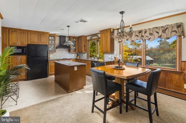 a view of a kitchen with kitchen island granite countertop a window and a sink