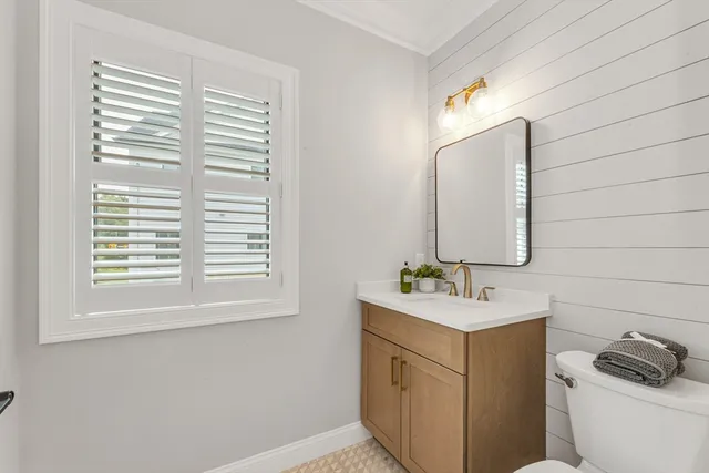a bathroom with a sink vanity granite toilet and a mirror
