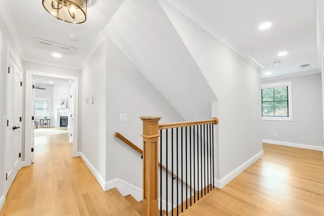 a view of a hallway with wooden floor and staircase