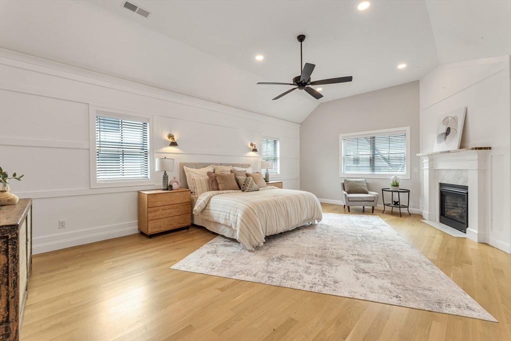 2 Brownson Terrace Boston, MA 02130 - Photo 5 of 30 a spacious bedroom with a large bed a chandelier and fireplace