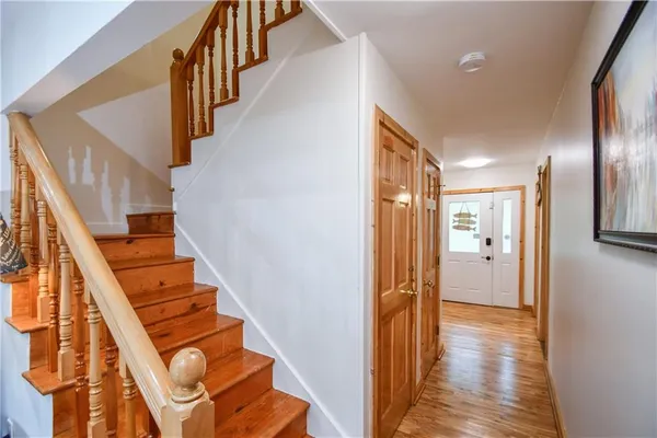a bedroom with a bed and a chair with the wooden floor
