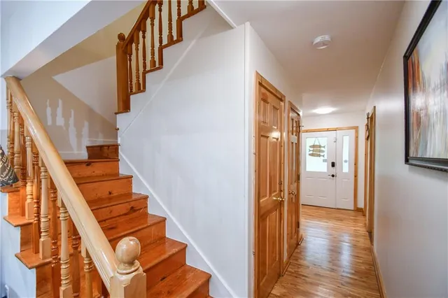 a bedroom with a bed and a chair with the wooden floor