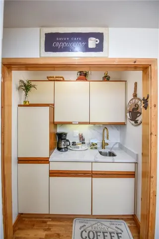 a kitchen with a stove and a dining table with wooden floor
