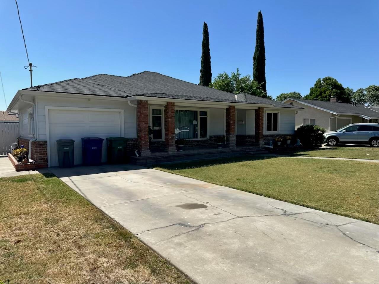 985 Grove Avenue Gustine, CA 95322 - Photo 4 of 14 a front view of a house with a garden and yard
