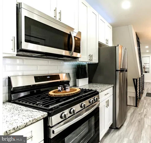 a kitchen with stainless steel appliances a stove a microwave and cabinets