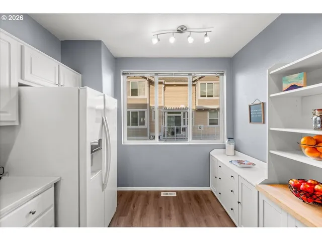 a kitchen with a refrigerator a stove a sink dishwasher and cabinets with wooden floor