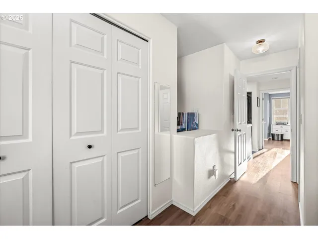 a hallway with white cabinets and wooden floor
