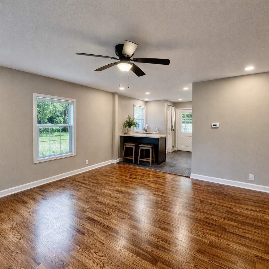 314 West 12th Street Metropolis, IL 62960 - Photo 14 of 29 a view of a livingroom with a kitchen wooden floor and a ceiling fan
