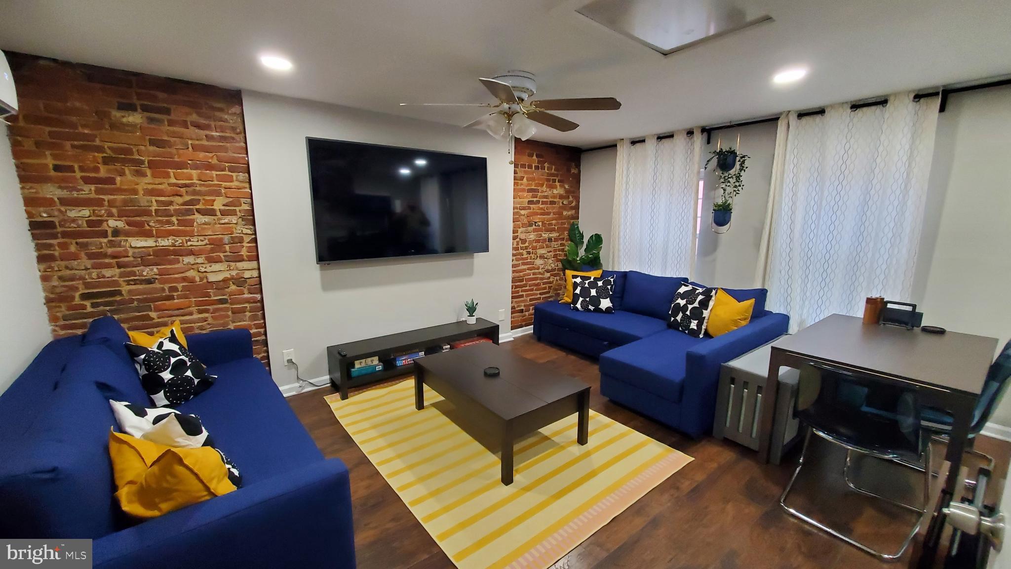 244 South Exeter Street, Unit 3 Baltimore, MD 21202 - Photo 2 of 18 a living room with furniture and a flat screen tv