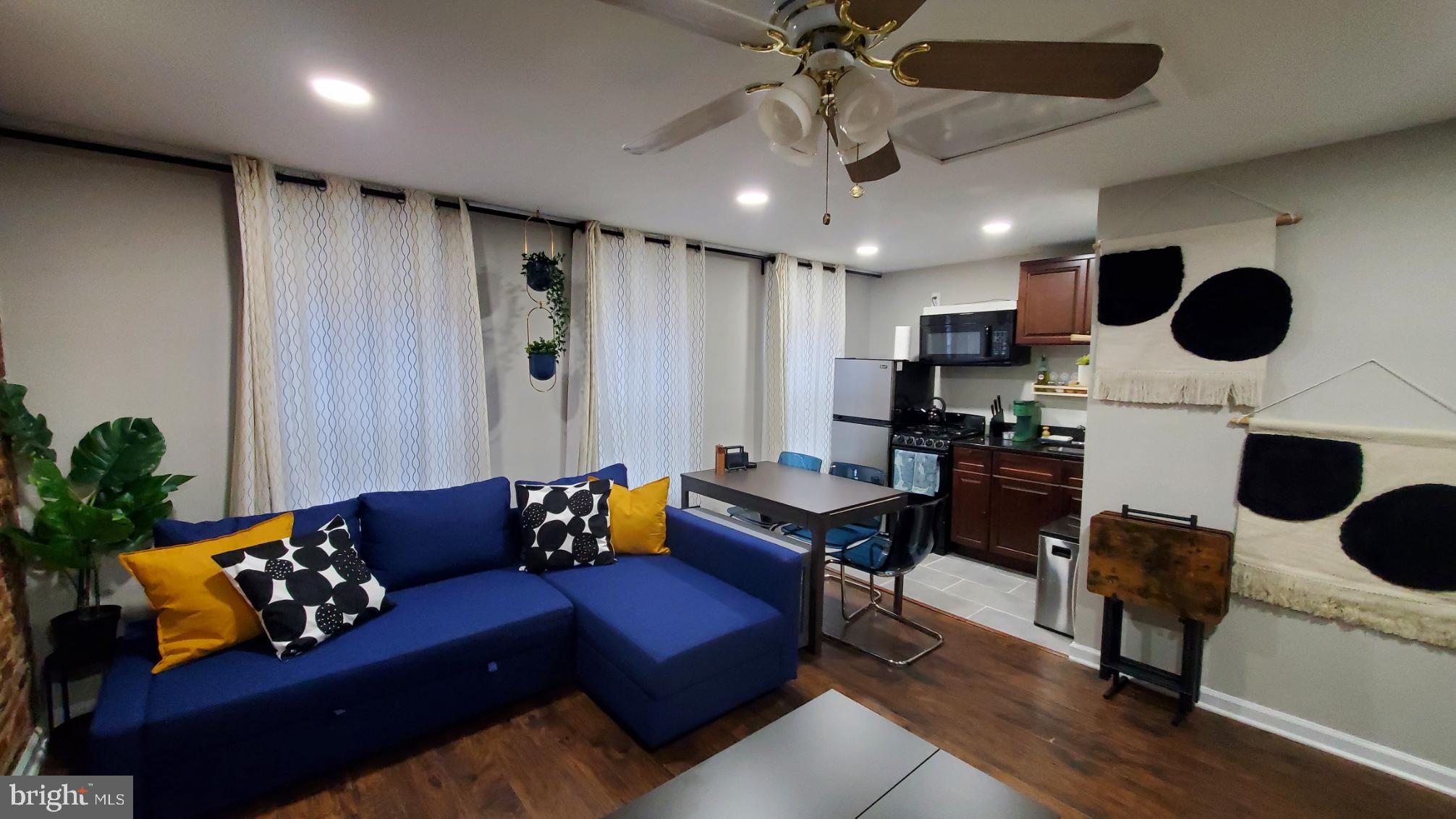 244 South Exeter Street, Unit 3 Baltimore, MD 21202 - Photo 3 of 18 a living room with furniture kitchen view and a chandelier