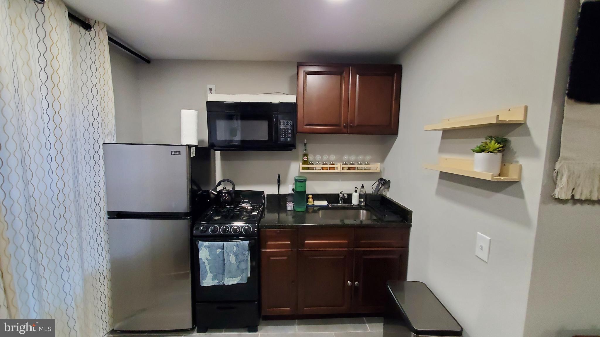 244 South Exeter Street, Unit 3 Baltimore, MD 21202 - Photo 4 of 18 a kitchen with a refrigerator and a stove top oven