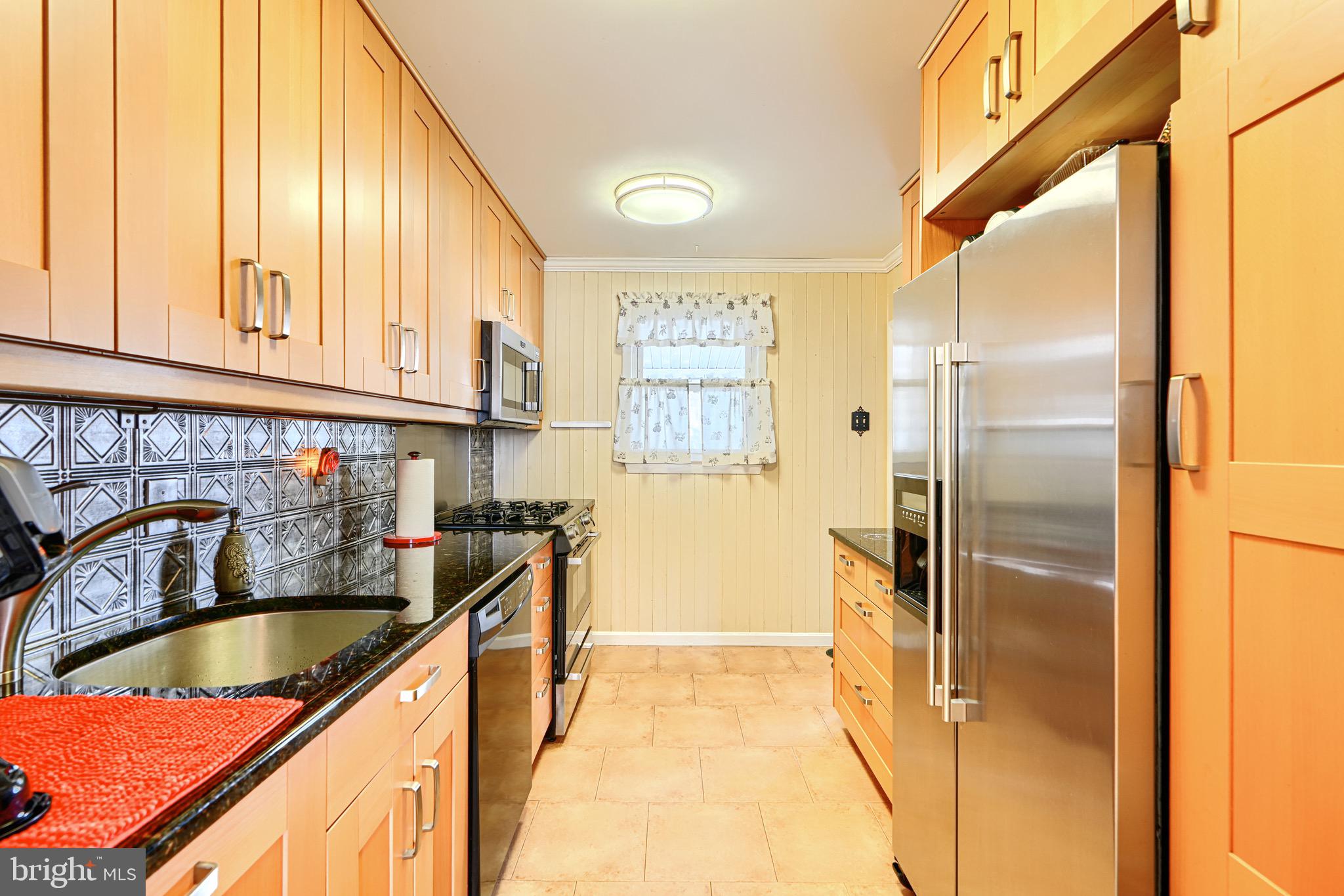 1605 Leslie Road Baltimore, MD 21222 - Photo 14 of 51 a kitchen with granite countertop a sink a refrigerator and cabinets