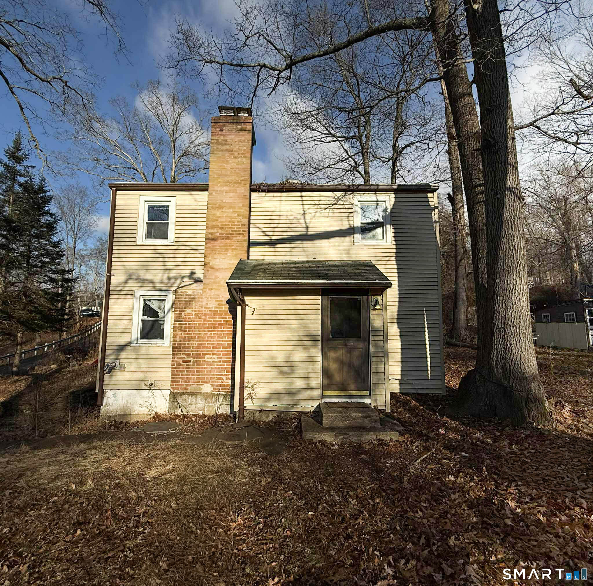 a view of a house with backyard and a tree