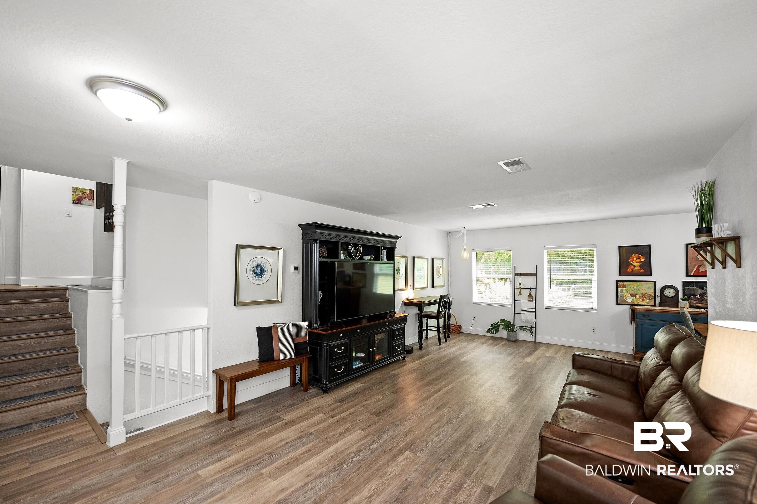 33129 Antietam Road Lillian, AL 36549 - Photo 20 of 31 Spacious room featuring wood-finish flooring, white walls, and multiple windows providing natural light