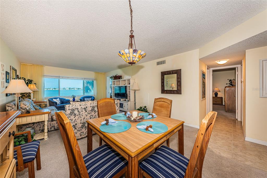 4750 Cove Circle, Unit 303 St. Petersburg, FL 33708 - Photo 15 of 64 a view of a dining room with furniture window and wooden floor