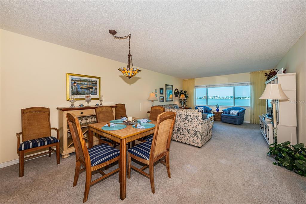 4750 Cove Circle, Unit 303 St. Petersburg, FL 33708 - Photo 16 of 64 a dining room with furniture and a chandelier