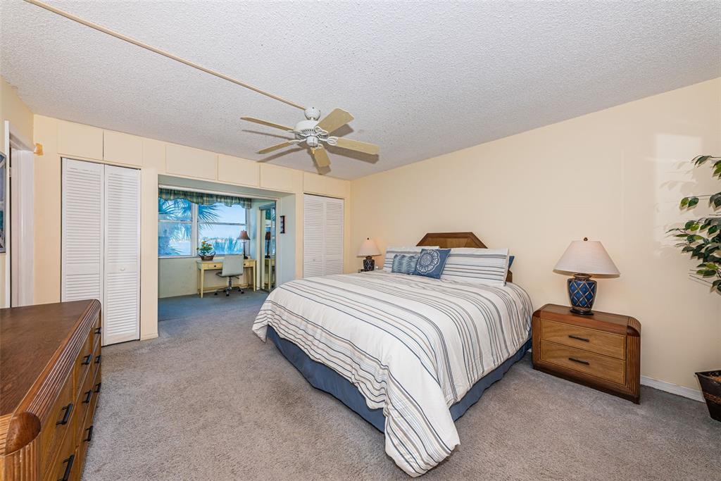 4750 Cove Circle, Unit 303 St. Petersburg, FL 33708 - Photo 24 of 64 a spacious bedroom with a bed and a chandelier
