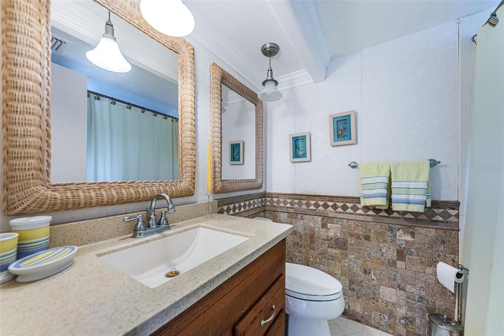 4750 Cove Circle, Unit 303 St. Petersburg, FL 33708 - Photo 26 of 64 a bathroom with a granite countertop sink mirror vanity and toilet