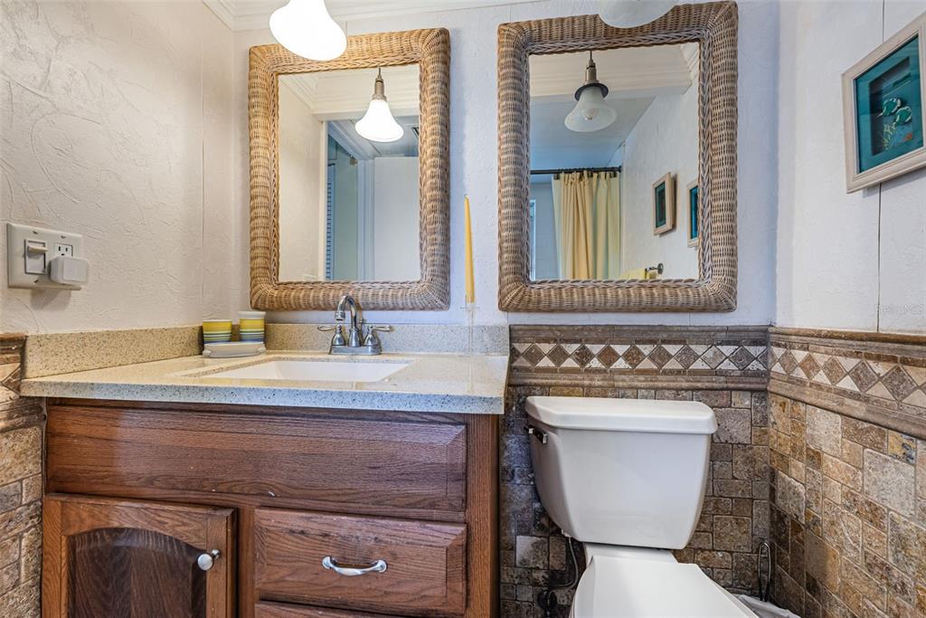 4750 Cove Circle, Unit 303 St. Petersburg, FL 33708 - Photo 27 of 64 a bathroom with a toilet a sink and mirror