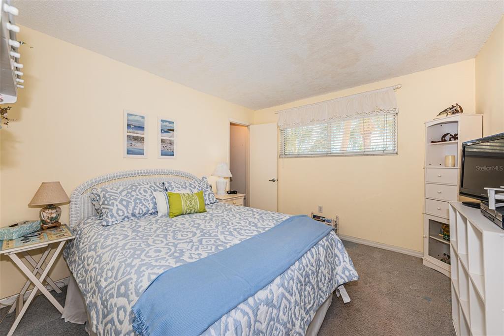 4750 Cove Circle, Unit 303 St. Petersburg, FL 33708 - Photo 28 of 64 a bedroom with a bed a couch and dresser