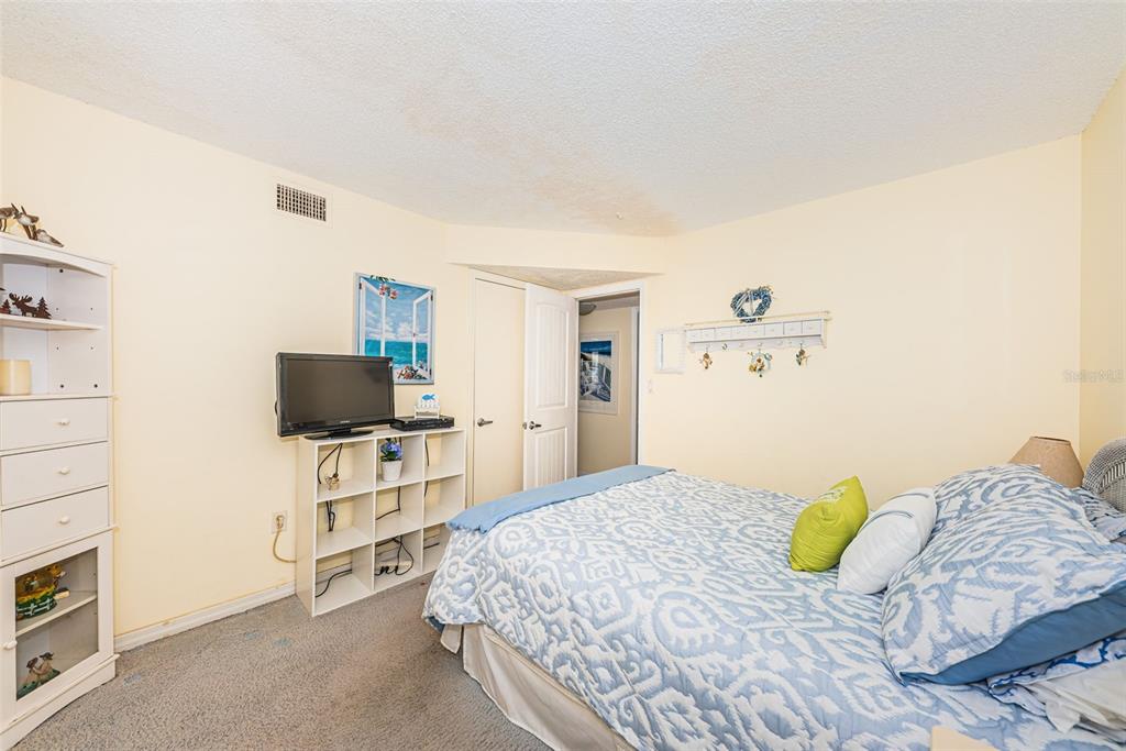 4750 Cove Circle, Unit 303 St. Petersburg, FL 33708 - Photo 29 of 64 a bedroom with a bed and a television