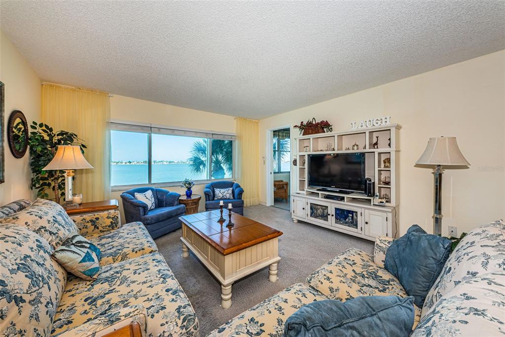 4750 Cove Circle, Unit 303 St. Petersburg, FL 33708 - Photo 3 of 64 a living room with furniture and a flat screen tv