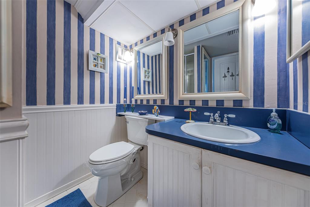 4750 Cove Circle, Unit 303 St. Petersburg, FL 33708 - Photo 31 of 64 a bathroom with a toilet a sink and a mirror