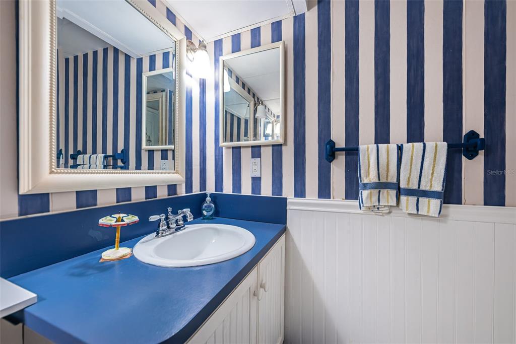 4750 Cove Circle, Unit 303 St. Petersburg, FL 33708 - Photo 33 of 64 a bathroom with sink a mirror a bathtub and a window