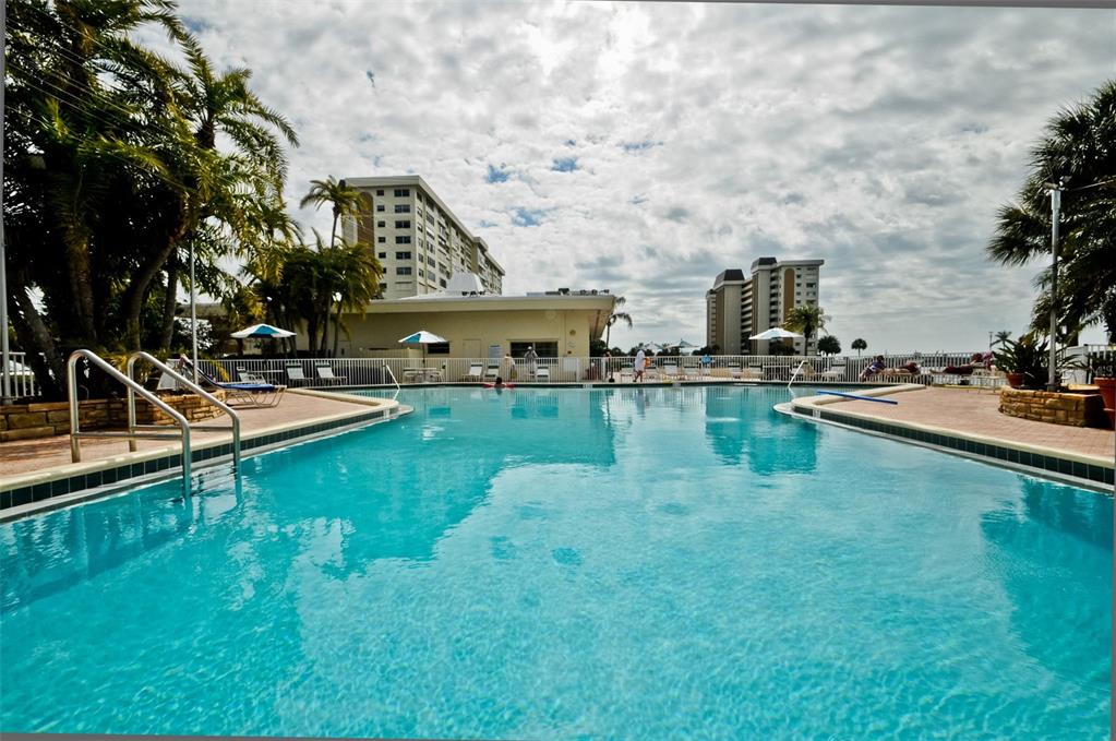 4750 Cove Circle, Unit 303 St. Petersburg, FL 33708 - Photo 46 of 64 a view of a swimming pool with a chair and tables