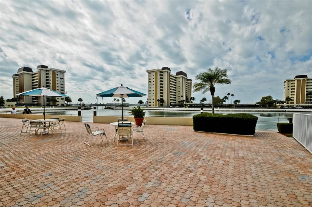 4750 Cove Circle, Unit 303 St. Petersburg, FL 33708 - Photo 47 of 64 a swimming pool with outdoor seating