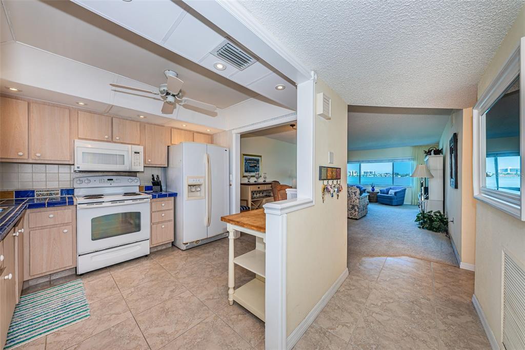 4750 Cove Circle, Unit 303 St. Petersburg, FL 33708 - Photo 7 of 64 a kitchen with white cabinets and stainless steel appliances