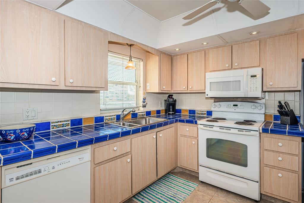 4750 Cove Circle, Unit 303 St. Petersburg, FL 33708 - Photo 9 of 64 a kitchen with white cabinets sink and white appliances