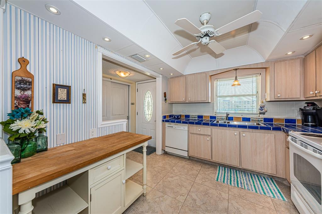 4750 Cove Circle, Unit 303 St. Petersburg, FL 33708 - Photo 10 of 64 a kitchen with a refrigerator and white cabinets