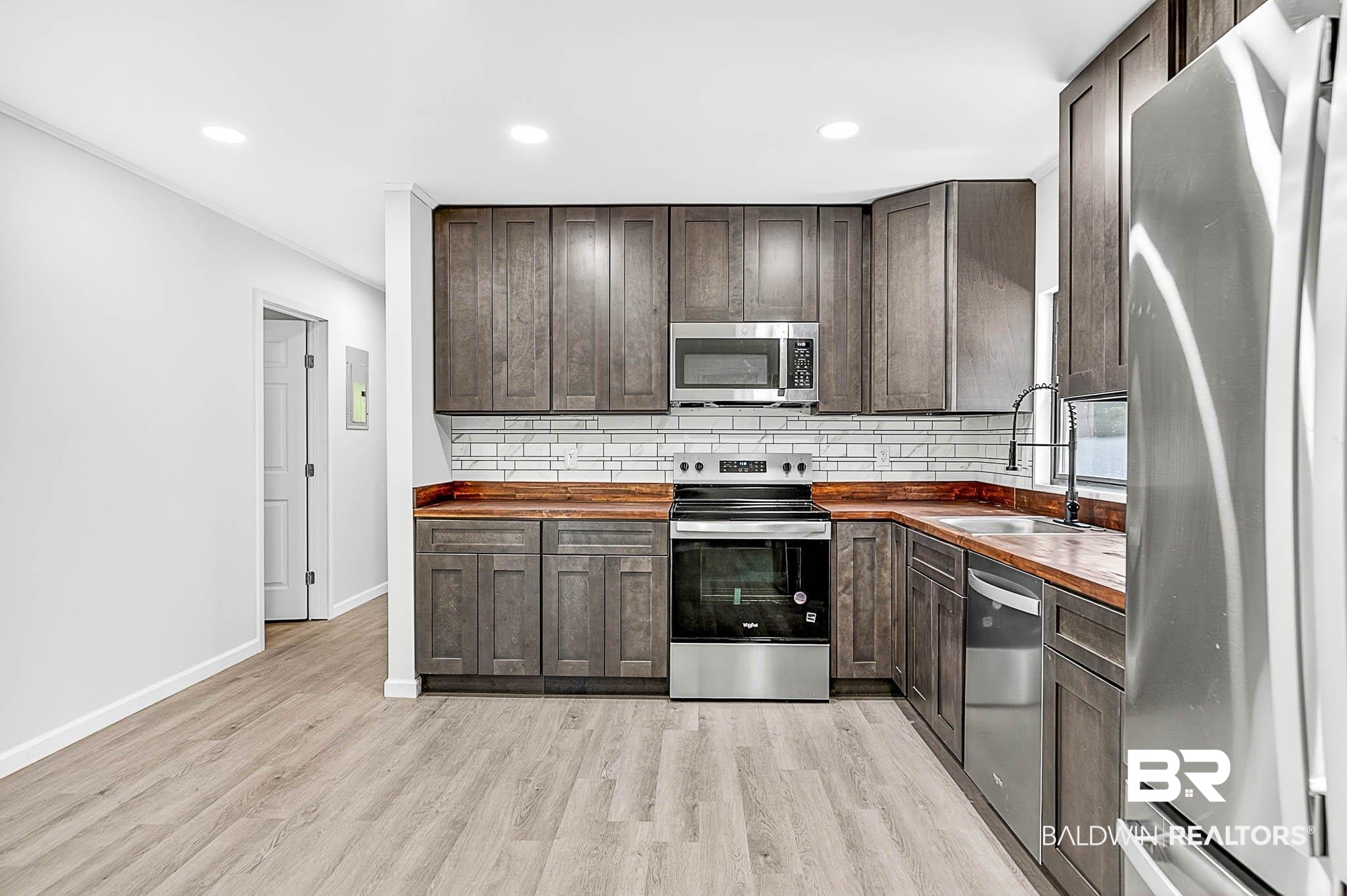 101 Terry Avenue Brewton, AL 36426 - Photo 31 of 48 Kitchen featuring wood counters, stainless steel appliances, dark brown cabinetry, backsplash, and light wood-type flooring