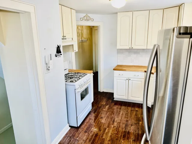 a kitchen with stainless steel appliances cabinets a sink and a large window