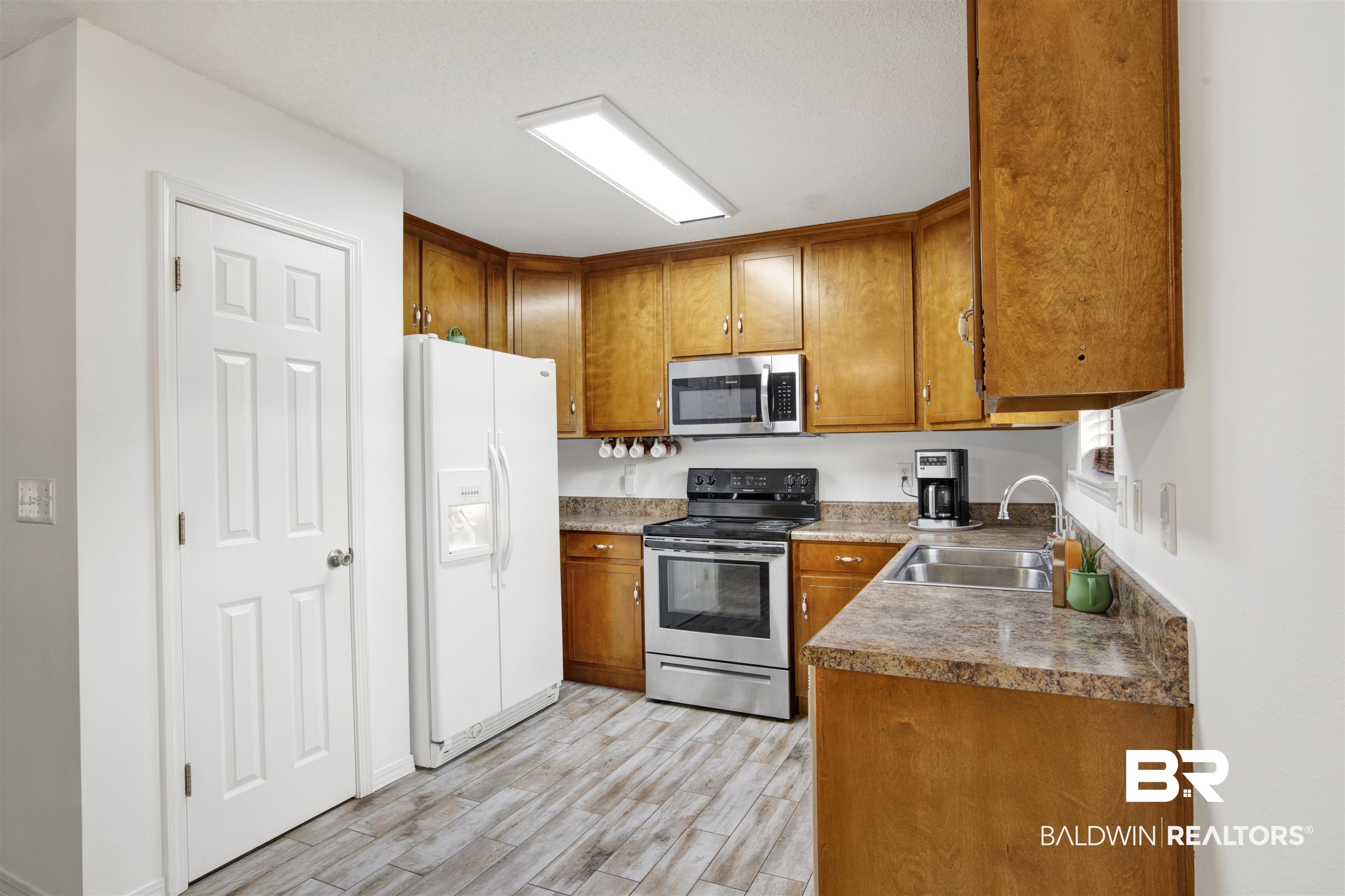 54563 Splinter Hill Road Perdido, AL 36562 - Photo 16 of 29 Kitchen with light wood-type flooring, sink, and appliances with stainless steel finishes