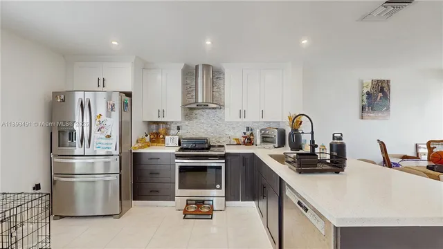 a kitchen with stainless steel appliances a sink a stove and cabinets